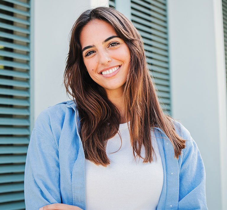 a woman in a blue shirt and smiling at the camera